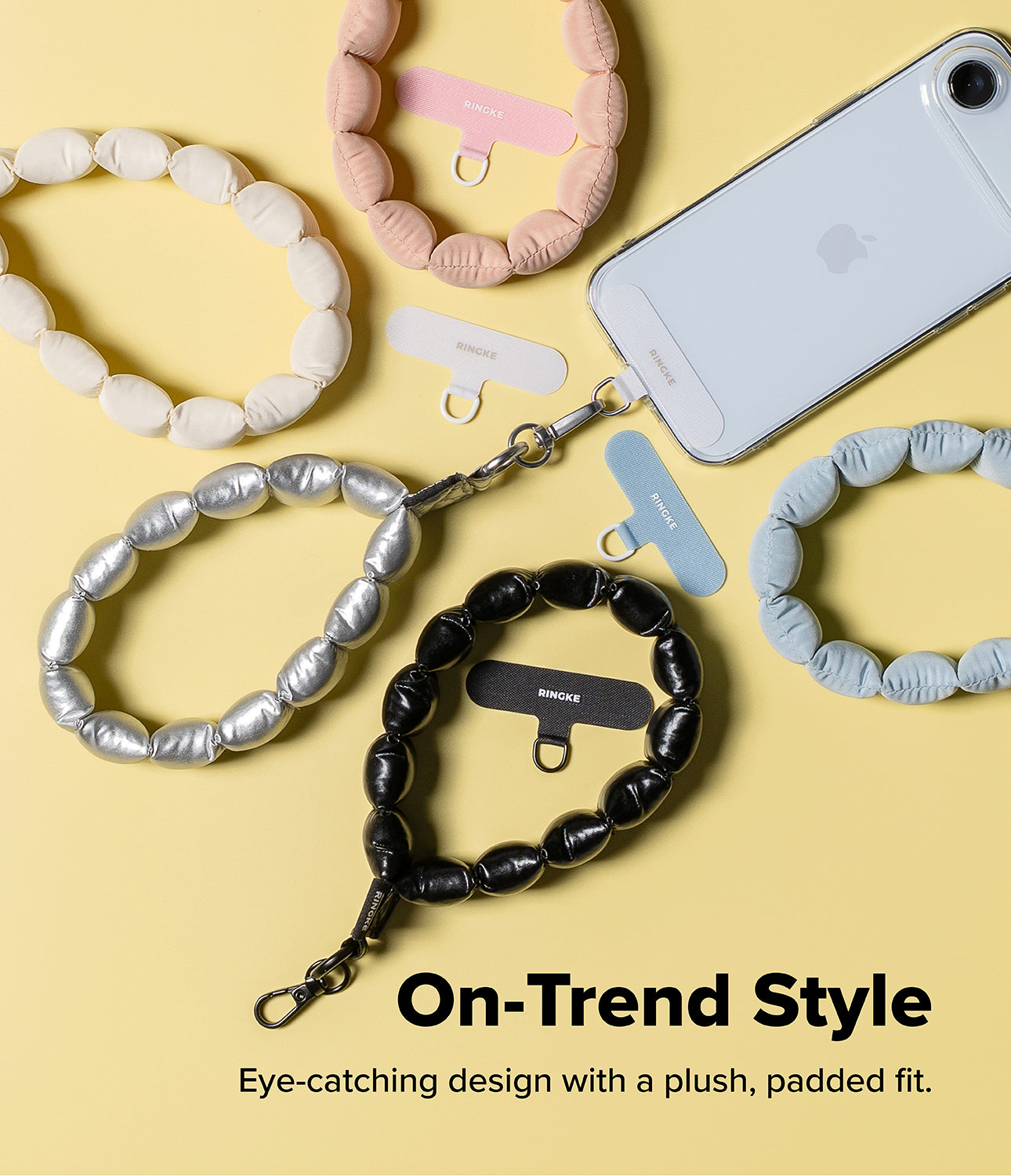 Holder Link Puffer | Hand - Five colorful, padded puffer-style phone wrist straps with matching adhesive anchor tabs.