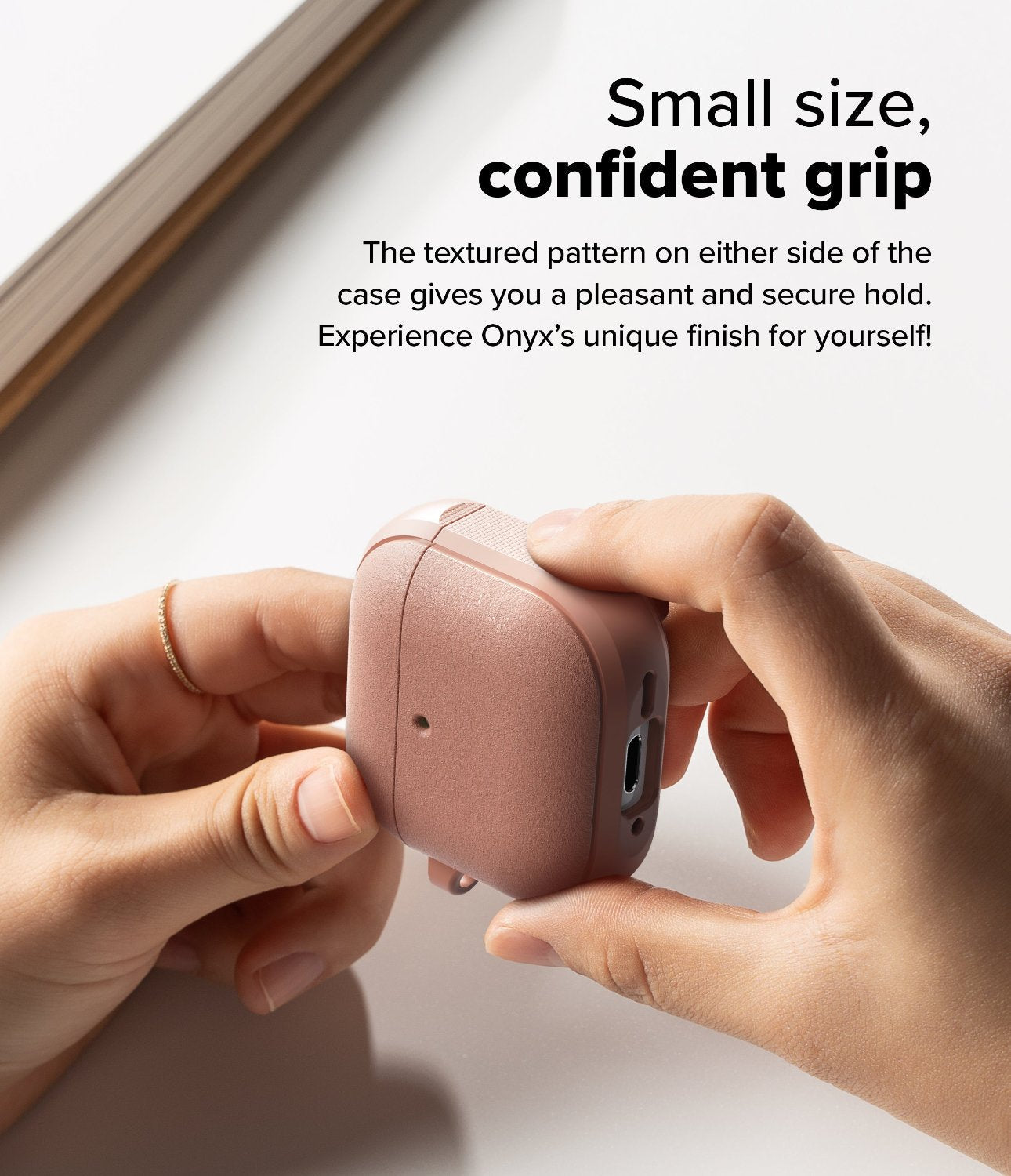 AirPods 4 Case | Onyx Magnetic - Hands holding a textured, dusty rose AirPods 4 case with side grip detailing.
