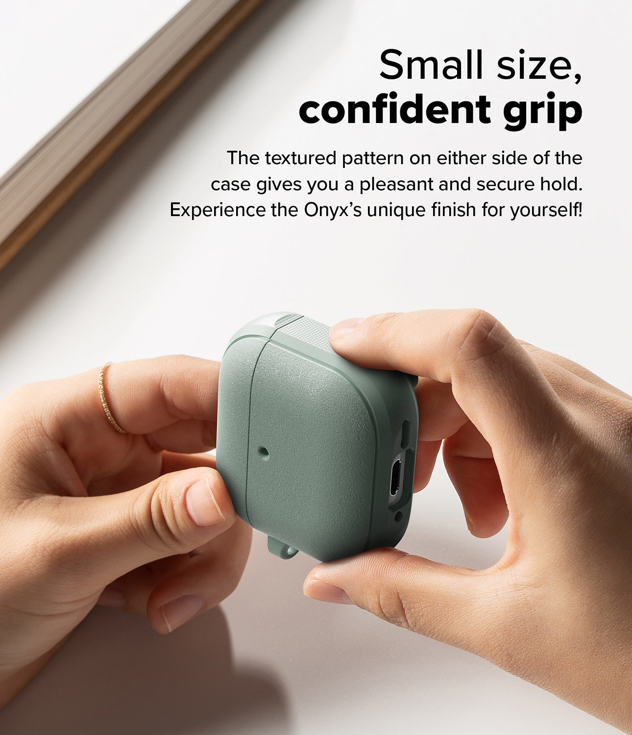 AirPods 4 Case | Onyx Magnetic - Hands holding a sage green textured AirPods 4 case with side grip detailing.