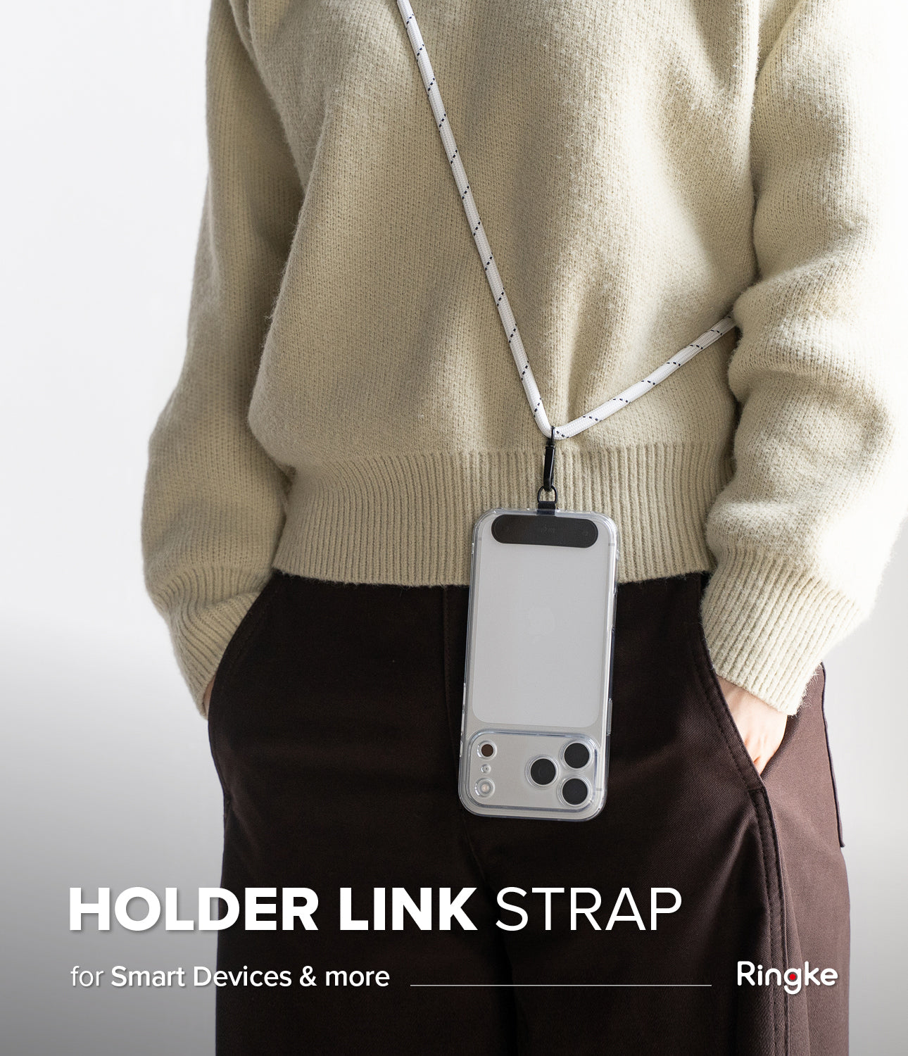 Holder Link Strap | Black - Person wearing a white rope phone lanyard attached to a clear smartphone case over a beige sweater.