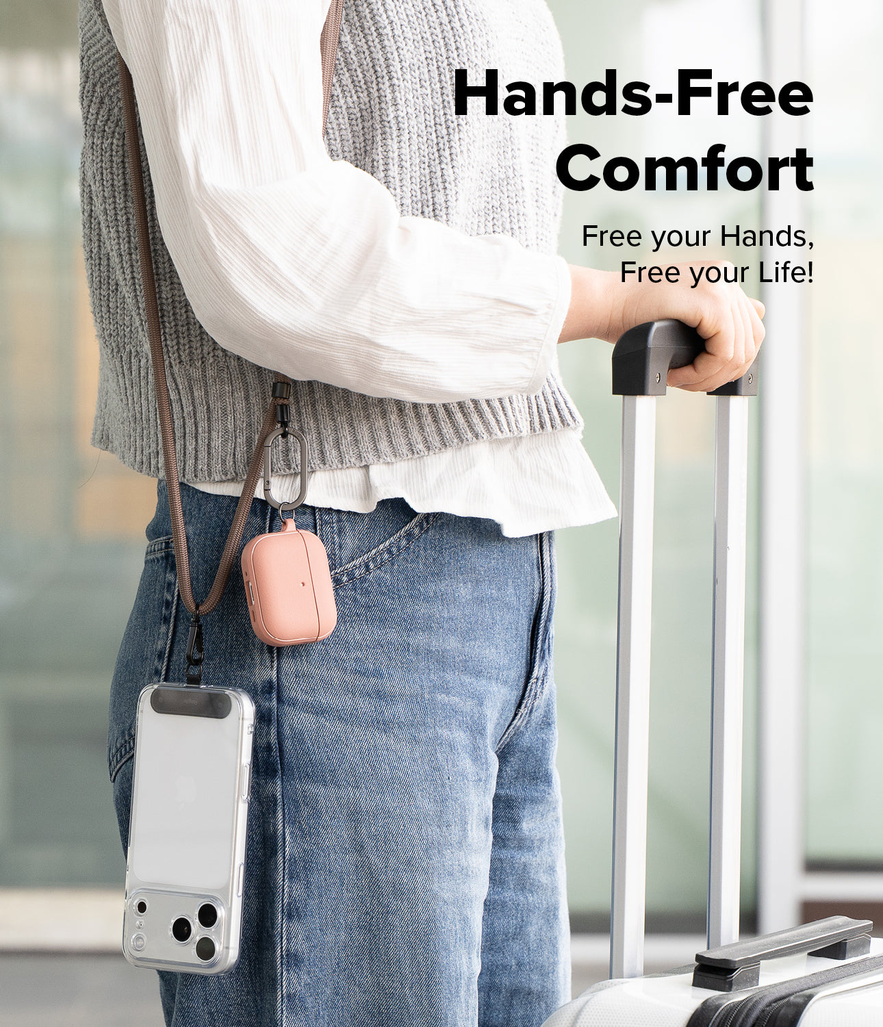 Holder Link Strap | Black - Person wearing a cross-body strap holding a phone case and pink earbud case while pulling luggage.