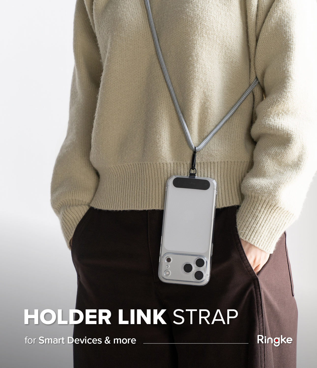 Holder Link Strap | Black - A person wearing a smartphone on a black and white woven neck strap over a beige sweater.