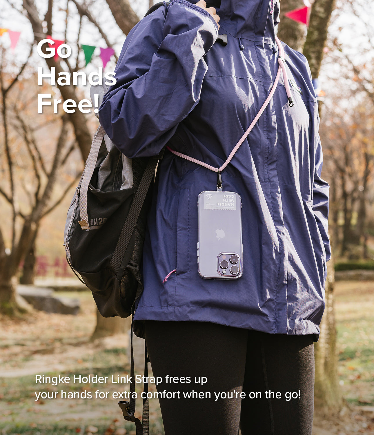 Holder Link Strap | Black - Person wearing a pink crossbody phone strap with a clear phone case in an outdoor park setting.