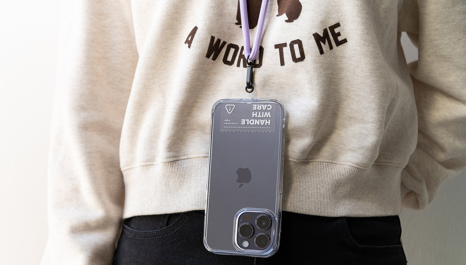 human wearing purple neck strap with clear tether tab attached on iPhone.