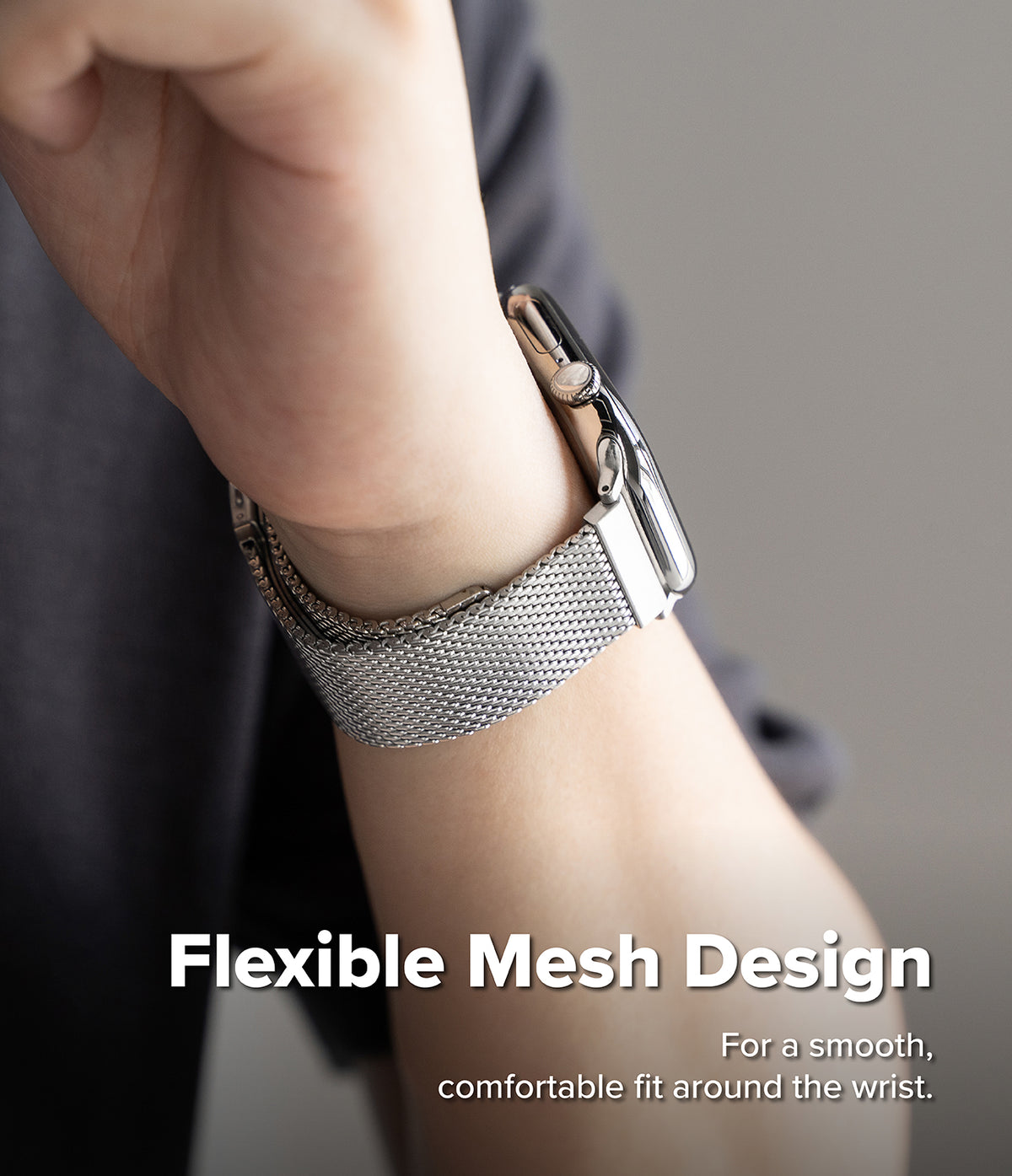 Apple Watch 49·46·45·44 mm | Metal One Mesh - A close-up of a person's wrist wearing a silver mesh watch band with a silver watch case, with text overlay reading 'Flexible Mesh Design' and 'For a smooth, comfortable fit around the wrist.'.