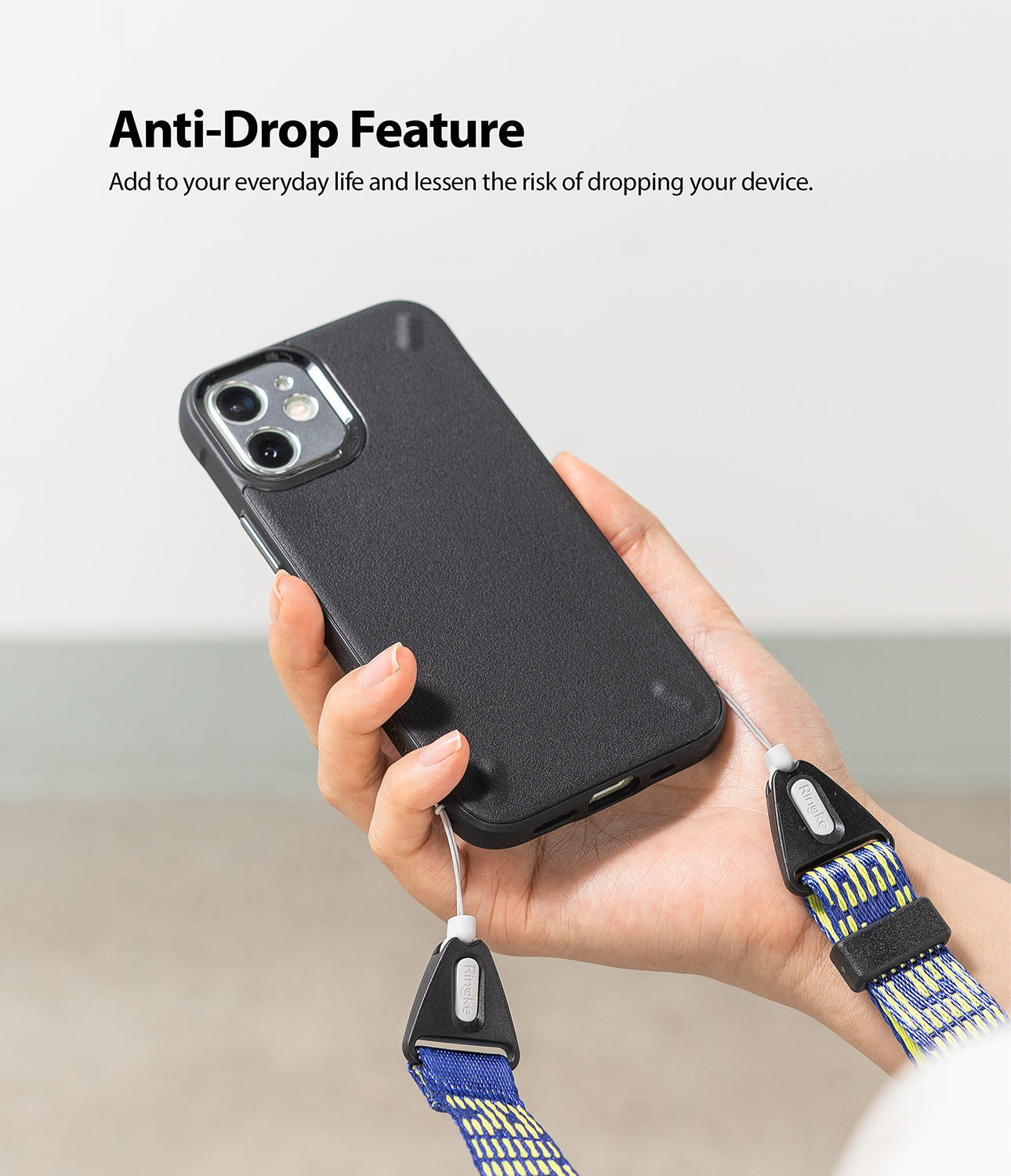Shoulder Strap | Lettering - Hand holding a black phone case attached to a blue and yellow patterned strap with Ringke branding.