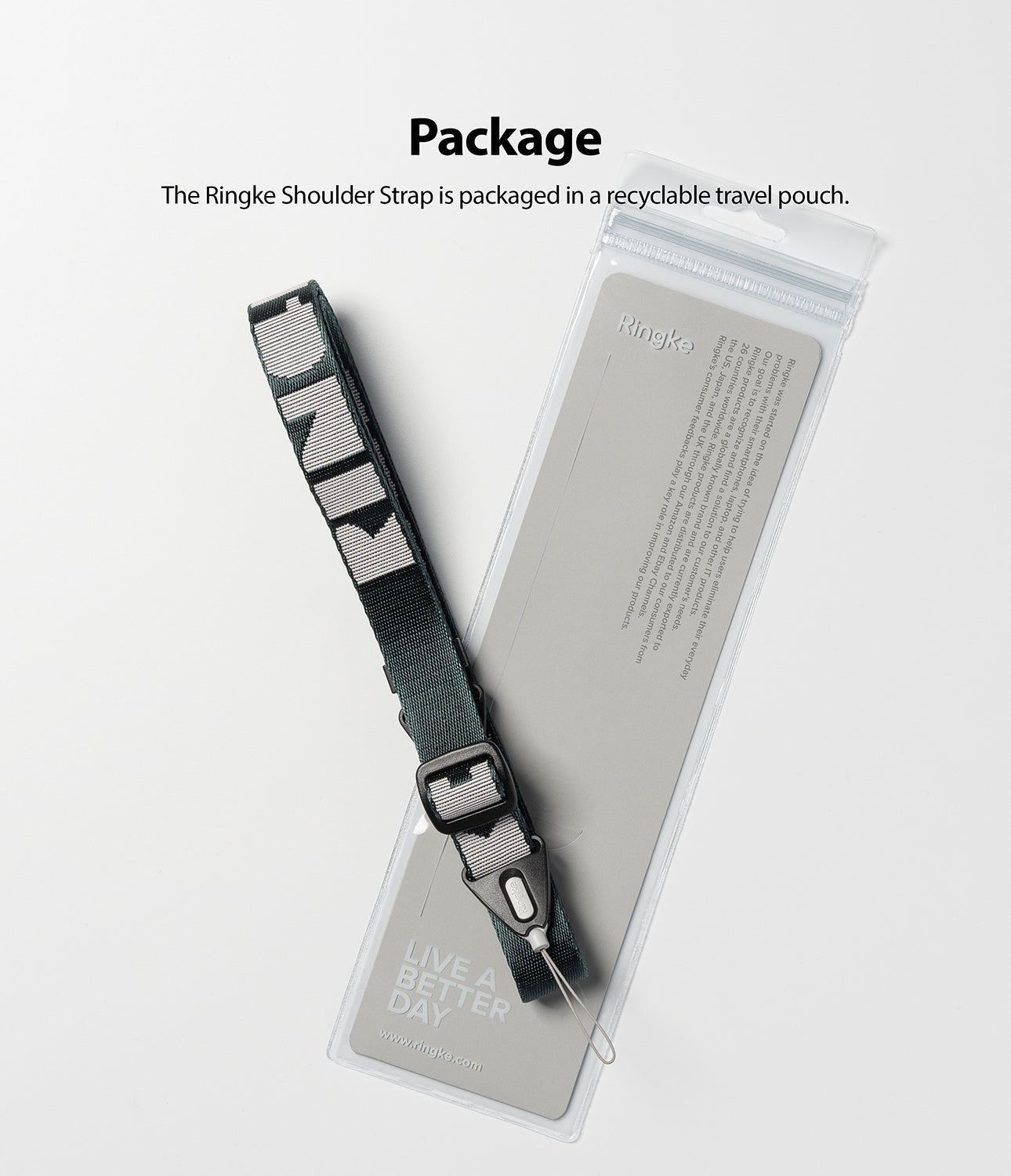 Shoulder Strap | Lettering - A grey shoulder strap with white lettering resting on its clear, branded retail packaging.