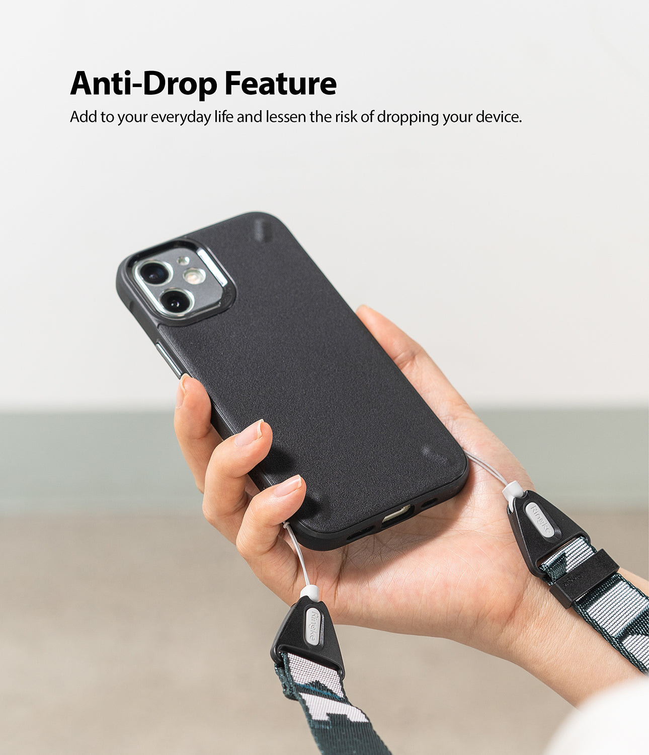 Shoulder Strap | Lettering - Hand holding a black phone case attached to a patterned shoulder strap with Ringke branding.