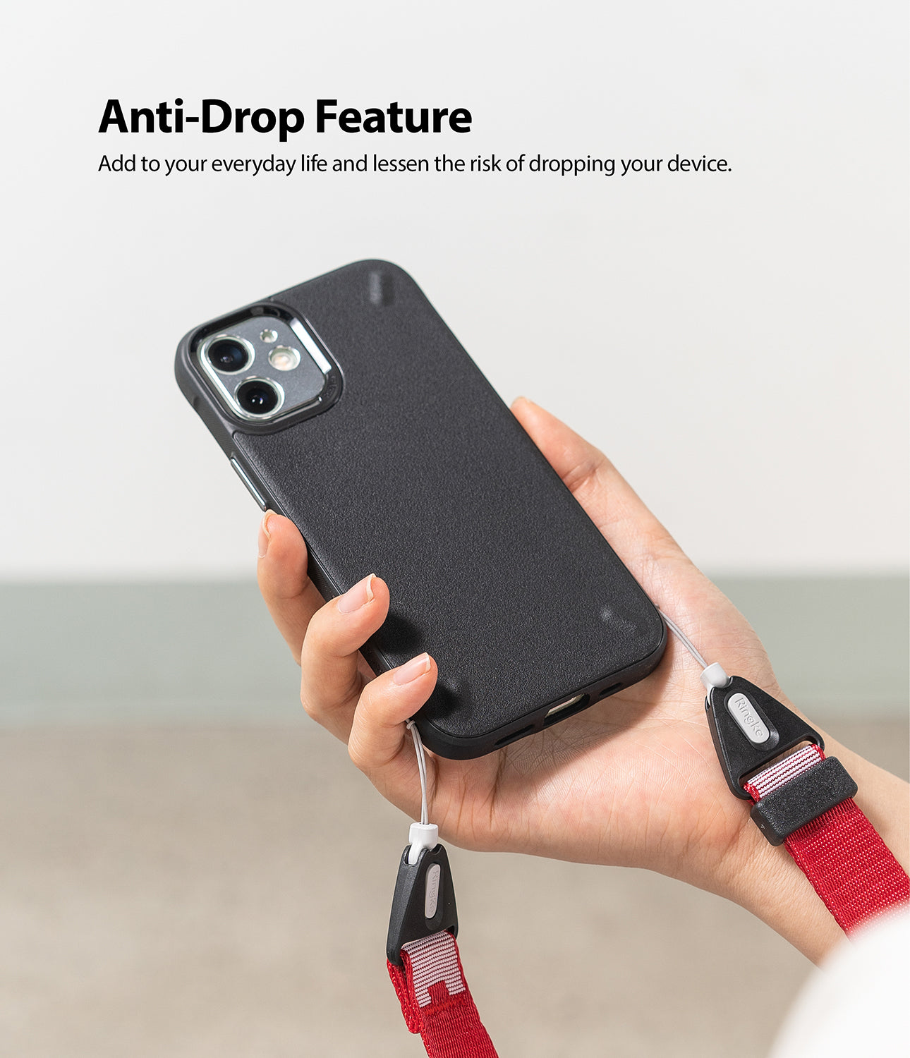 Shoulder Strap | Lettering - Hand holding a black phone case with a red and white branded shoulder strap attached for anti-drop.