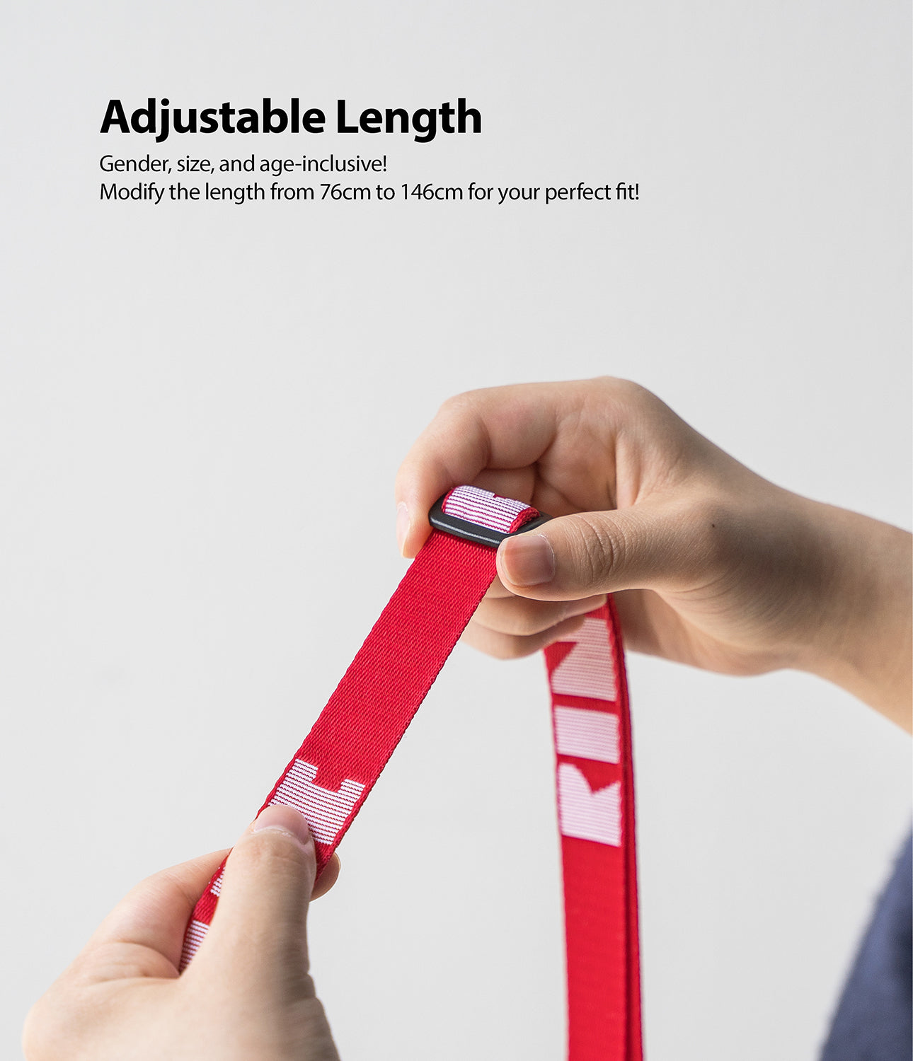 Shoulder Strap | Lettering - Hands adjusting the length of a red strap with white lettering using a black plastic buckle.