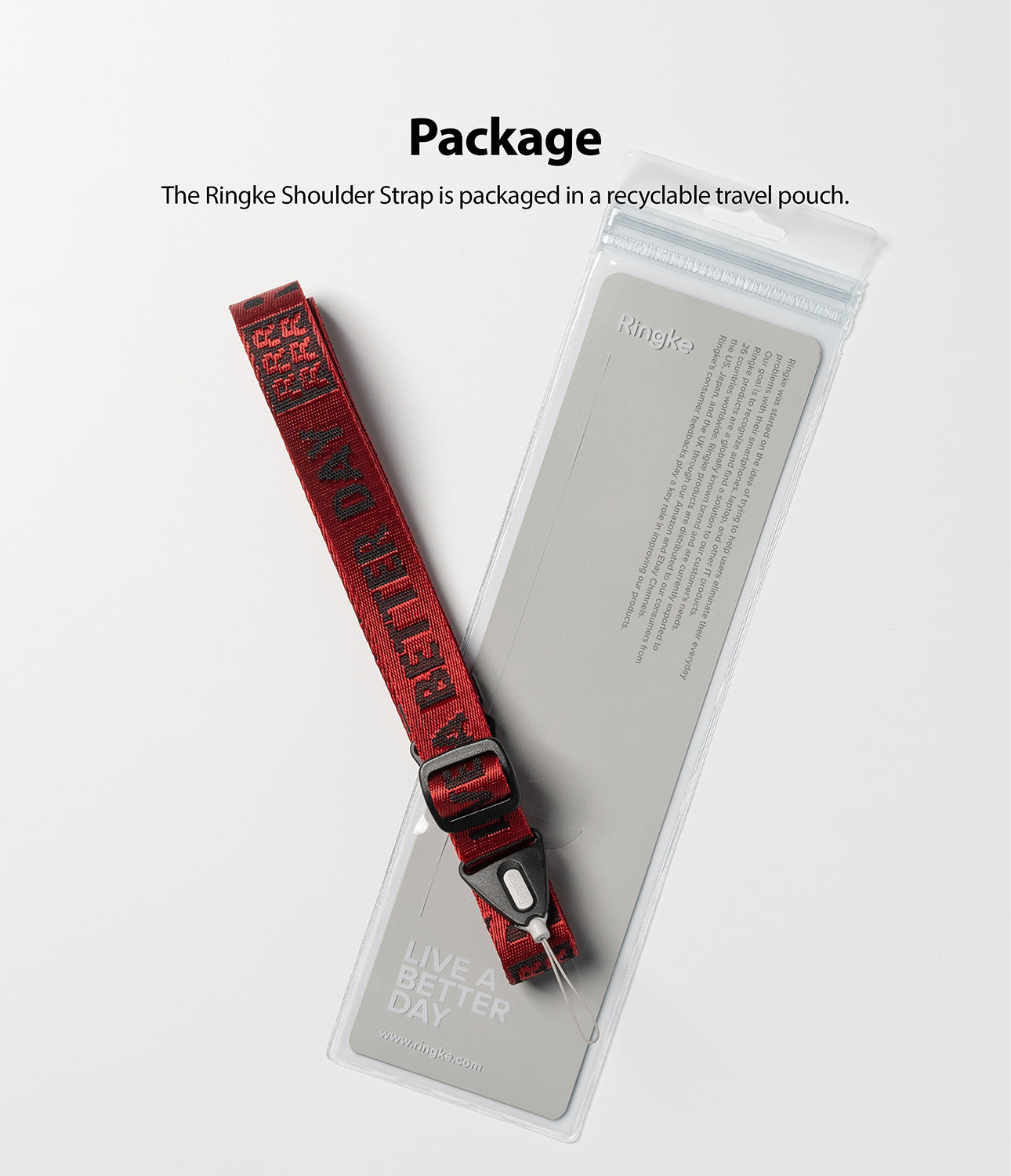 Shoulder Strap | Lettering - Red shoulder strap with black lettering resting on its clear, branded recyclable packaging pouch.