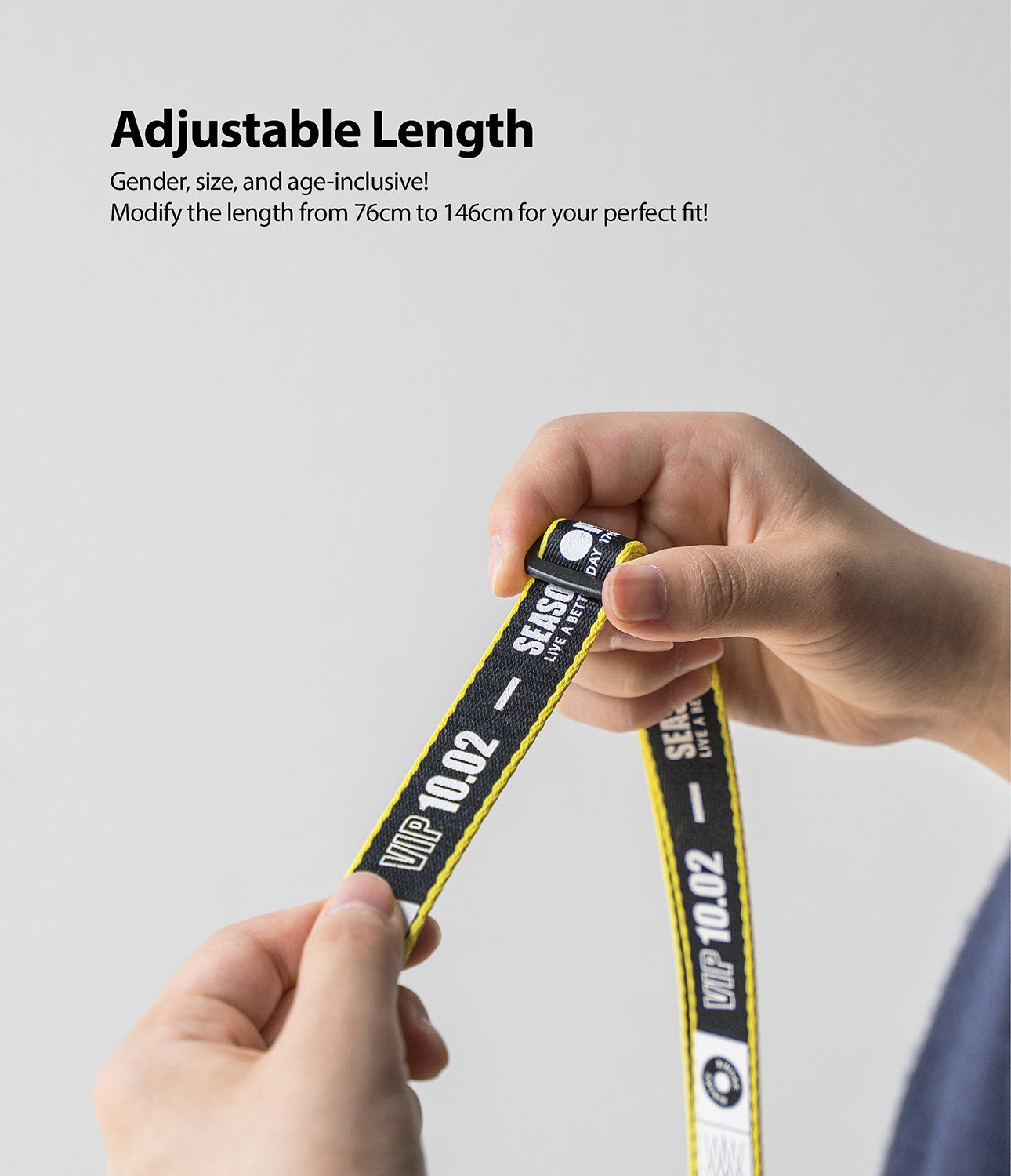Shoulder Strap | Lettering - Hands adjusting a black and yellow strap featuring white text and a sliding buckle.