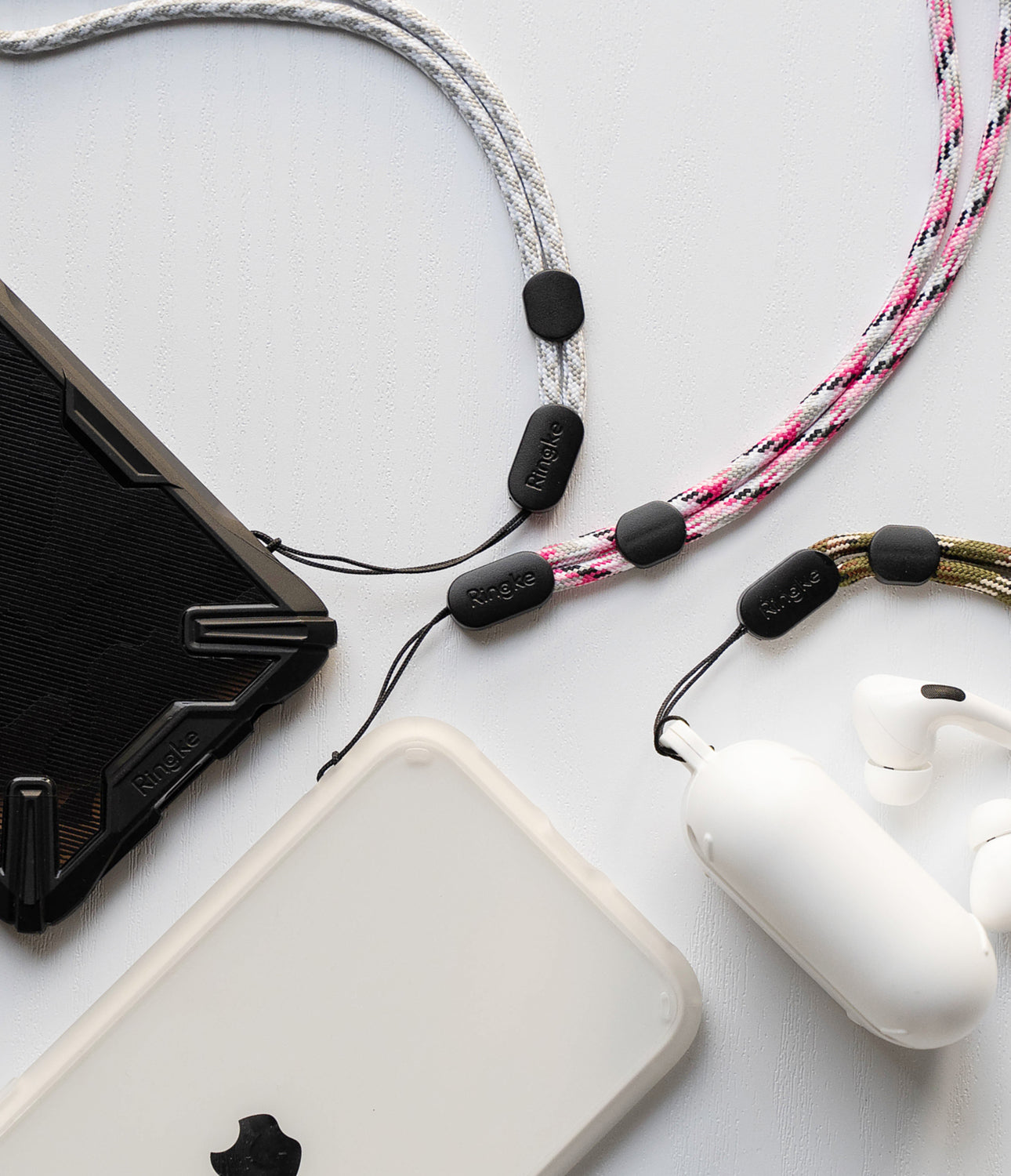 ringke paracord wrist strap with various electronic devices such as smartphones and apple airpods pro