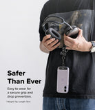 Holder Link Puffer | Finger - Person holding a phone with a puffer finger strap, wearing a black shirt with a graphic design.