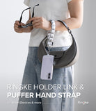 Holder Link Puffer | Hand - Person holding a gray handbag with a puffer strap and Ringke holder link, on a light gray background.