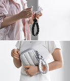 Holder Link Puffer | Hand - Person holding a silver pouch with a matching strap, against a plain background
