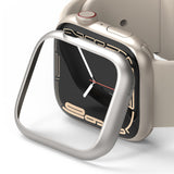 Apple Watch 9 / 8 / 7 (41mm) | Bezel Styling - A silver metallic bezel accessory hovering over a beige Apple Watch.