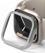 Apple Watch 9 / 8 / 7 (41mm) | Bezel Styling Premium - Silver fluted metal bezel cover hovering over a beige Apple Watch.