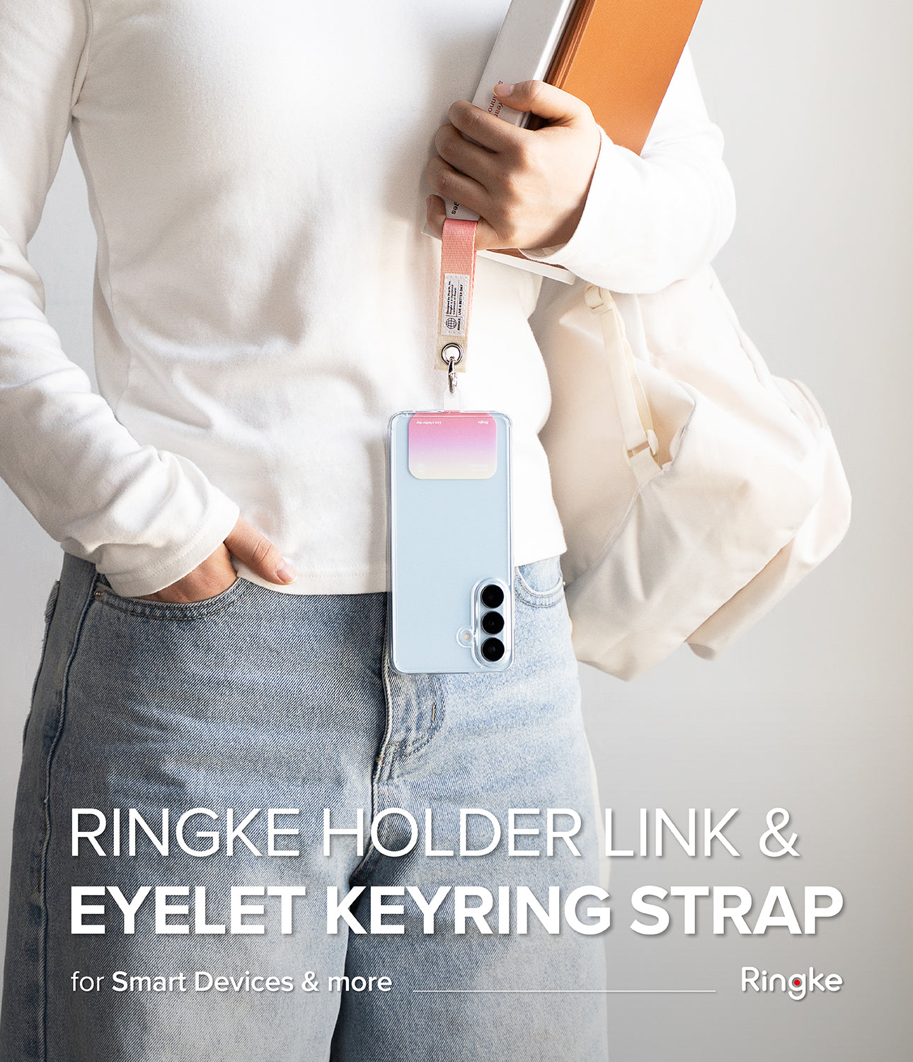 Holder Link Eyelet Keyring - A person wearing a phone case with a pink and white fabric strap attached to a metal eyelet.