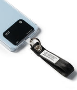 Holder Link Eyelet Keyring - A black fabric wrist strap attached to a phone case via a metal ring and a clear plastic tab.