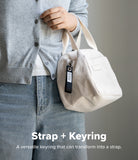 Holder Link Eyelet Keyring - A black fabric keyring attached to a white corduroy bag held by a person in a grey cardigan.