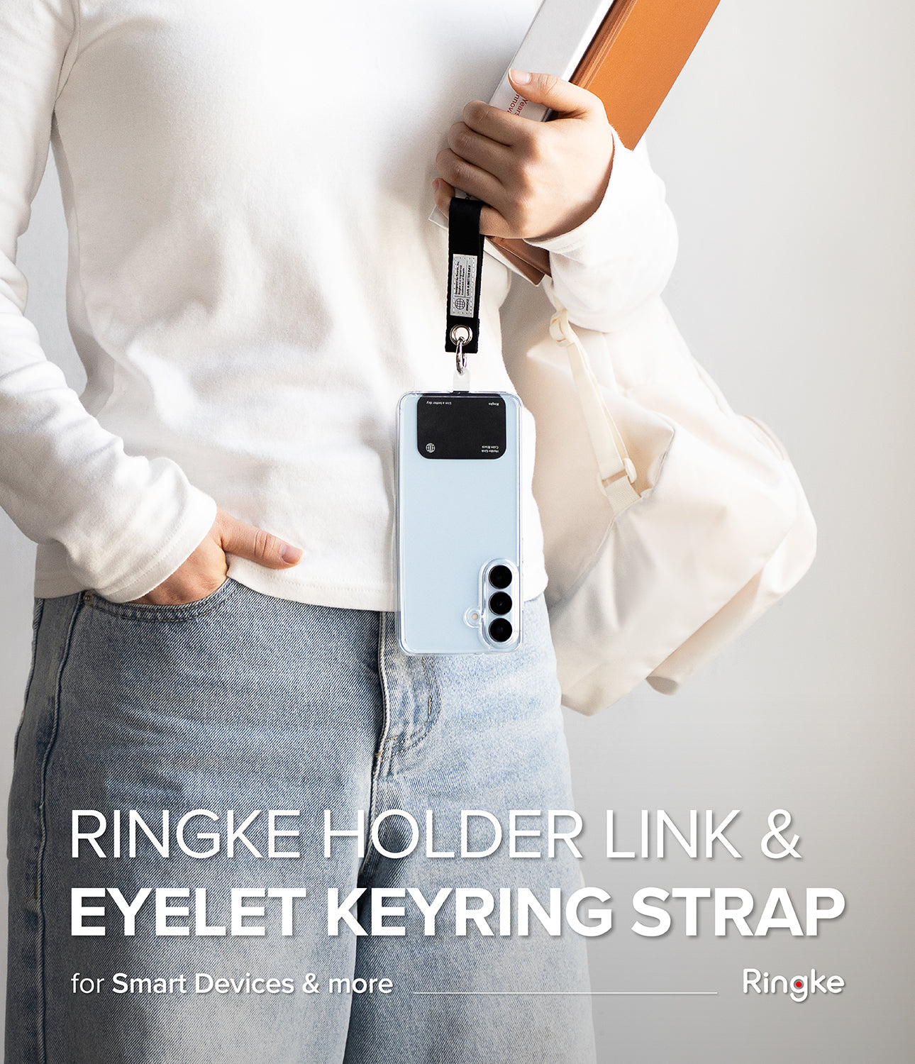 Holder Link Eyelet Keyring - A person holding a phone with a black strap attached to a metal eyelet keyring.