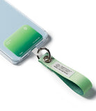 Holder Link Eyelet Keyring - A green fabric wrist strap attached to a phone case via a metal ring and clear plastic tab.