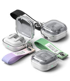 Four small wireless earbud cases with clear plastic lids and attached wrist straps, shown in different strap colors on a light gray background. The cases appear to be silver and white, with one open case revealing the earbuds inside.