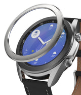 Galaxy Watch 3 (41mm) | Bezel Styling - A silver metal bezel ring hovering above a Galaxy Watch 3 with a blue digital face.