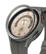 Galaxy Watch 5 Pro 45mm | Inner Bezel Styling - A metallic bezel ring hovering above a grey smartwatch with a compass face.