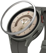 Galaxy Watch 5 Pro 45mm | Bezel Styling - A silver metal bezel ring hovering above a grey Galaxy Watch 5 Pro.