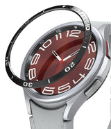 Galaxy Watch 6 Classic 43mm | Bezel Styling - Galaxy Watch 6 Classic 43mm - A black bezel ring hovering above a silver smartwatch with a red face and white numerals.