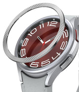 Galaxy Watch 6 Classic 47mm | Premium Bezel Styling - Silver textured bezel ring hovering above a smartwatch with a red face.