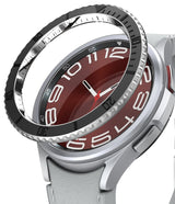 Galaxy Watch 6 Classic 47mm | Premium Bezel Styling - Galaxy Watch 6 Classic 47mm - A black metal bezel ring hovering above a silver smartwatch with a red analog watch face.
