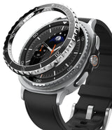 Galaxy Watch 8 Classic 46mm | Bezel Styling Premium - Galaxy Watch 8 Classic 46mm - A metallic bezel ring hovering above a smartwatch with a black leather strap and moon dial.