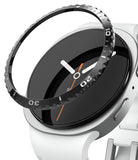Galaxy Watch 9 / 8 40mm | Bezel Styling - A close-up of a smartwatch with a white band and silver case, featuring a black watch dial and a transparent protective bezel ring with white numerals.