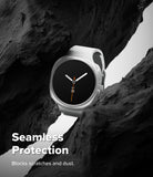Galaxy Watch 8 40mm Case | Slim - A white smartwatch with a black round face is shown nestled between dark rock formations. White text at the bottom reads 'Seamless Protection' and 'Blocks scratches and dust.