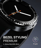 Galaxy Watch 9 / 8 44mm | Bezel Styling Premium - Close-up promotional render of a black Samsung Galaxy Watch 9 bezel with a textured metallic ring around the watch face. The watch band is dark gray/black, and the screen shows a minimalist analog watch face.