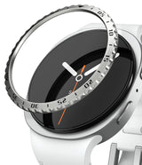 Galaxy Watch 9 / 8 44mm | Bezel Styling - A close-up of a smartwatch with a white band and silver case, showing a clear bezel protector ring with black printed numerals and white hands partially covering the black watch face.