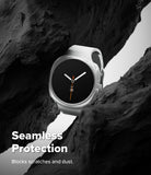 Galaxy Watch 9 / 8 44mm Case | Slim - A white smartwatch with a black round face is shown nestled between dark rock formations. White text at the bottom reads 'Seamless Protection' and 'Blocks scratches and dust.