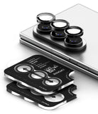Galaxy Z Fold 8 Ultra | Camera Lens Frame Glass (2 Pack) - Three black camera lens protectors with silver edges are shown, with one set mounted on the camera module of a silver smartphone and a second set displayed flat in front with printed installation arrows and text.
