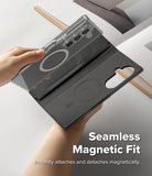 Galaxy Z Fold 8 Ultra MagSafe Wallet | Folio Grip Wallet Magnetic - A phone folio case shown being held by two hands, with one hand lifting a transparent magnetic cover layer over a dark gray folio base. The case includes a camera cutout, card slot, and circular magnetic ring.