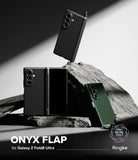 Galaxy Z Fold 8 Ultra Case | Onyx Flap - Three black phone cases shown with Samsung Galaxy Z Fold8 Ultra foldable phones in a styled studio setup with rocks and dramatic lighting. Text at the bottom reads 'ONYX FLAP for Galaxy Z Fold8 Ultra' with the Ringke logo and 'Pinake Original Design' mark.
