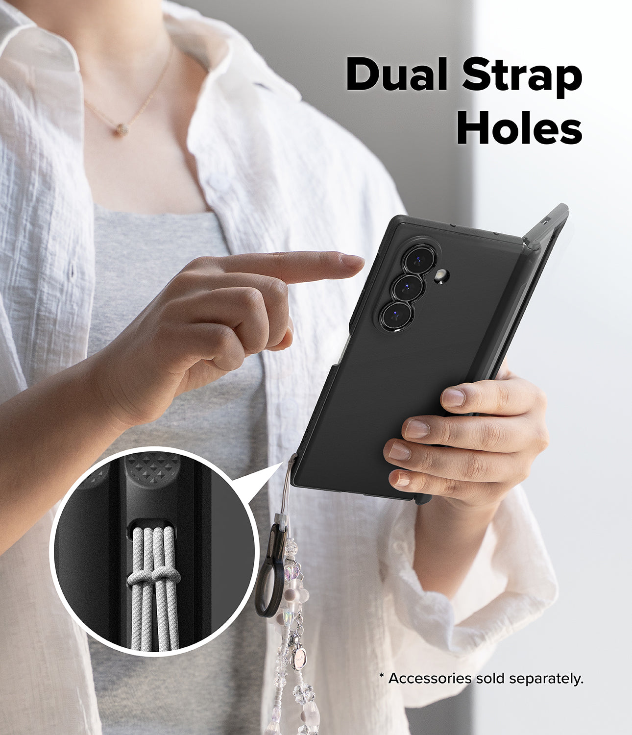 Galaxy Z Fold 8 Ultra Case | Onyx Flap Magnetic - A person holds a black smartphone case with a dangling strap in one hand while pointing to a circular inset showing the dual strap hole detail. Large text reads 'Dual Strap Holes' and small text says accessories are sold separately.