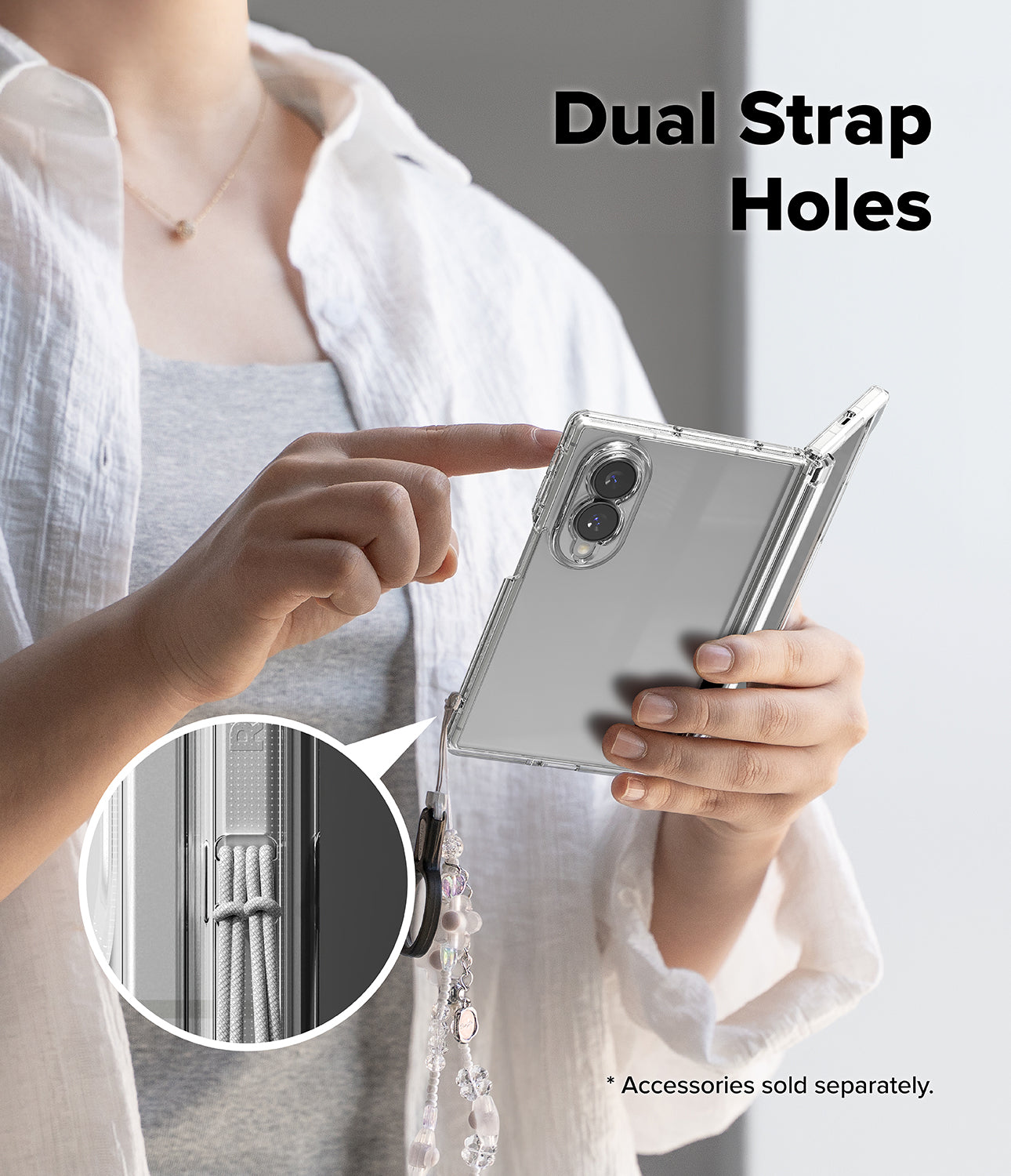 Galaxy Z Fold 8 Case | Fusion Flap - A person holds a silver folding smartphone in a transparent case, pointing to dual strap holes on the side. A circular inset shows a close-up of the elastic strap attachment.