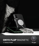 Galaxy Z Fold 8 Case | Onyx Flap Magnetic - A black magnetic phone case with a transparent flap is shown on a Samsung Galaxy Z Fold8, resting on a rock against a dark background. A second phone with a dark green case lies below it.
