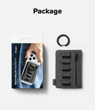 Wallet  | Tech Magnetic - A dark gray tech wallet magnetic accessory shown next to its retail packaging on a light gray background, with the word 'Package' printed at the top. The wallet has a zippered main compartment, multiple black magnetic loops, and a small black ring attached to the side.