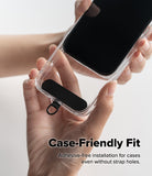 Holder Link Strap | Black - Hands placing a black adhesive-free strap anchor inside a clear phone case.