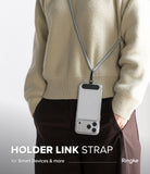 Holder Link Strap | Black - A person wearing a smartphone on a black and white woven neck strap over a beige sweater.