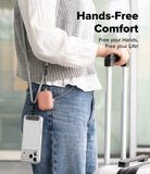 Holder Link Strap | Black - Person wearing a crossbody strap holding a phone and pink earbud case while pulling luggage.